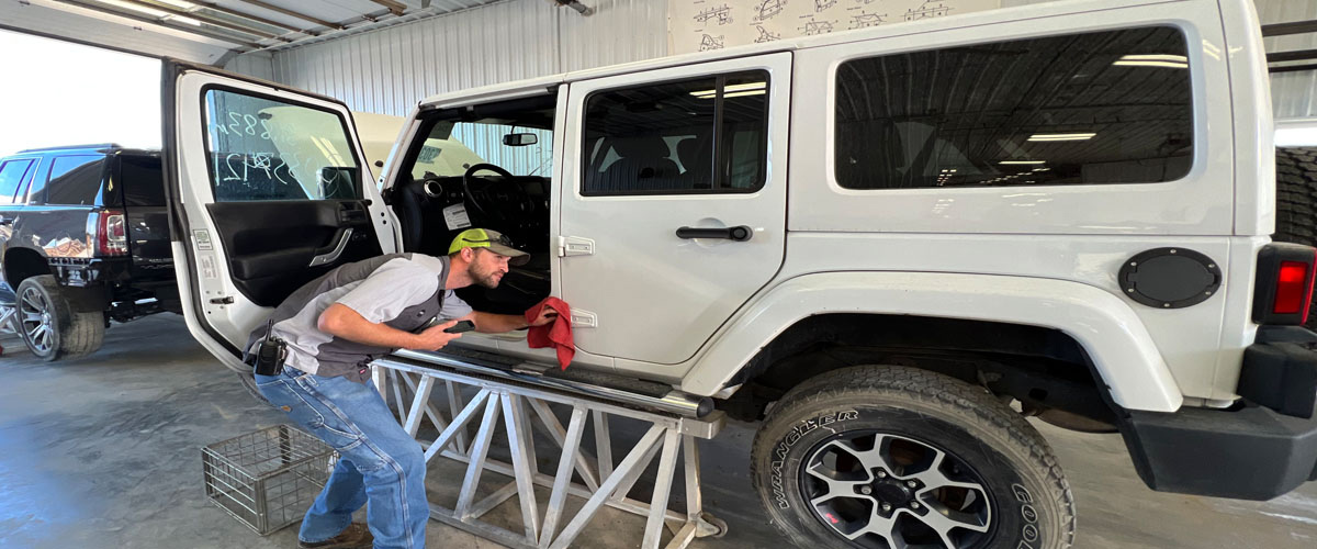 Y Yard tech looking over a door on a vehicle